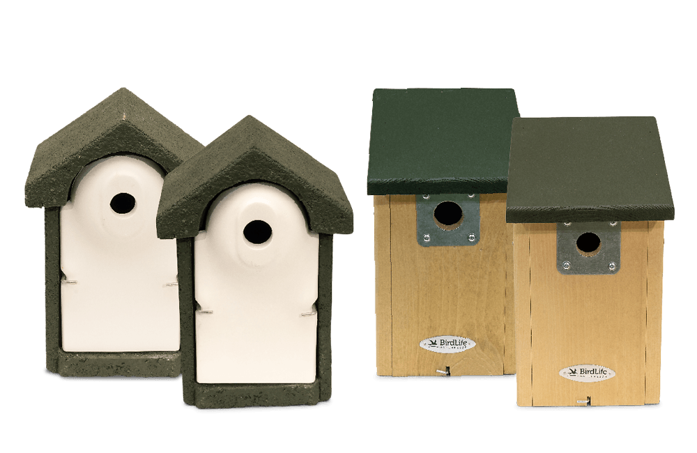 4 Nistkästen aus der BirdLife Österreich Serie - 2 Holzbeton-Nistkästen und 2 Holznistkästen. Die Holznistkästen haben eine Logo-Plakette.