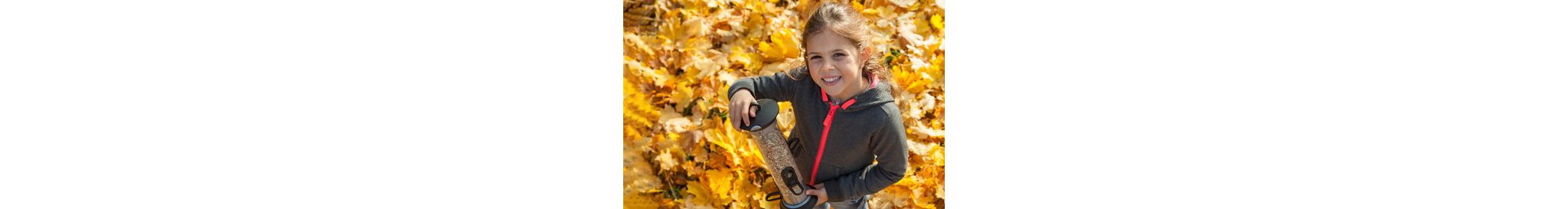 Child stands radiantly with her Apollo feeding system, which contains seeds